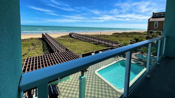 A pool area with a view of the beach and ocean. - Amberjack Oasis  (South Padre Island)