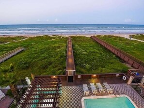 Zona de piscina al terrat amb vista a la platja i a l'oceà.