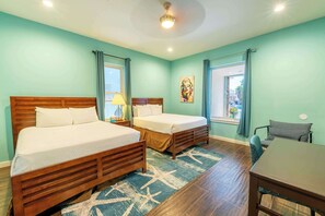 Une chambre à coucher avec deux lits en bois, un bureau et une chaise.