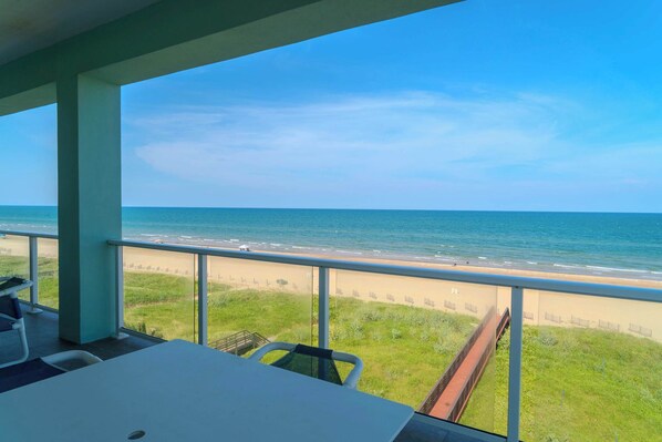 Een balkon met uitzicht op het strand en de oceaan.