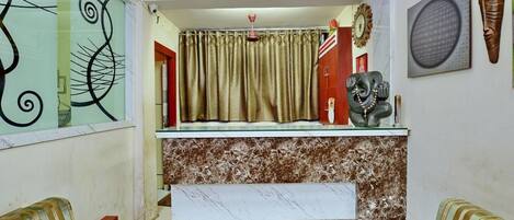 Un espacio habitable pequeño con zona de cocina, un sofá y una estatua decorativa de un elefante.