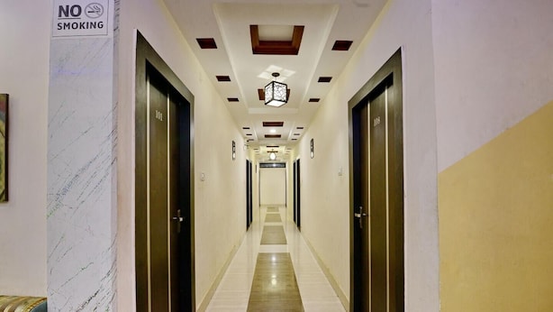 Ein Hotelkorridor mit einer Marmorwand links, einem Rauchverbotsschild und Türen mit den Nummern 101 und 108.