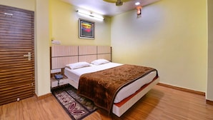 Ein Schlafzimmer mit Bett, Nachttischtelefon, Wandleuchte und Deckenventilator.