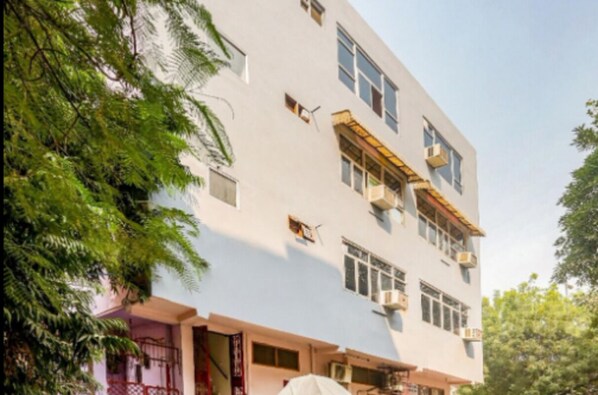 A multi-story building with a flat facade, multiple windows, and balconies. - Hotel Perfect Inn (New Delhi)