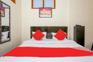 A hotel room with a bed, a mirror, a painting, and a wardrobe. - Hotel Perfect Inn (New Delhi)