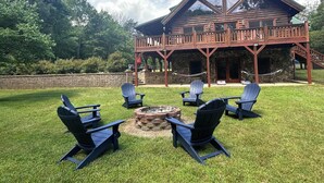 A lodge with a stone facade, a covered deck, and a fire pit surrounded by Adirondack chairs. - A Slice of Salisbury-Pool, Hottub 10 Acre (Salisbury)