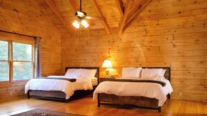 A cabin-style room with two wooden beds, a ceiling fan, and a large window. - A Slice of Salisbury-Pool, Hottub 10 Acre (Salisbury)