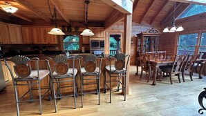 A wooden cabin interior with a kitchen, dining area, and large windows. - A Slice of Salisbury-Pool, Hottub 10 Acre (Salisbury)