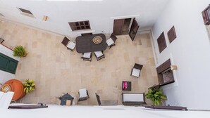 Eine Dachterrasse mit Esstisch, Stühlen und Topfpflanzen.