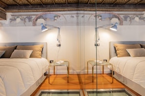 A room with two beds, each with a lamp and a glass table. - Casa Savoia by Wonderful Italy (Turin)