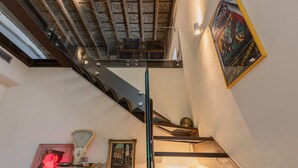 A staircase with a glass railing, a ceiling with intricate patterns, and a framed artwork on the wall. - Casa Savoia by Wonderful Italy (Turin)