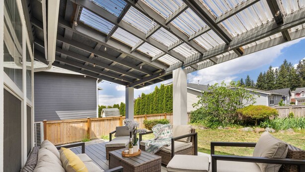 A covered patio area with wicker furniture and a glass ceiling.