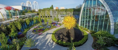 A landscaped garden with a central circular area, surrounded by modern buildings with glass facades.