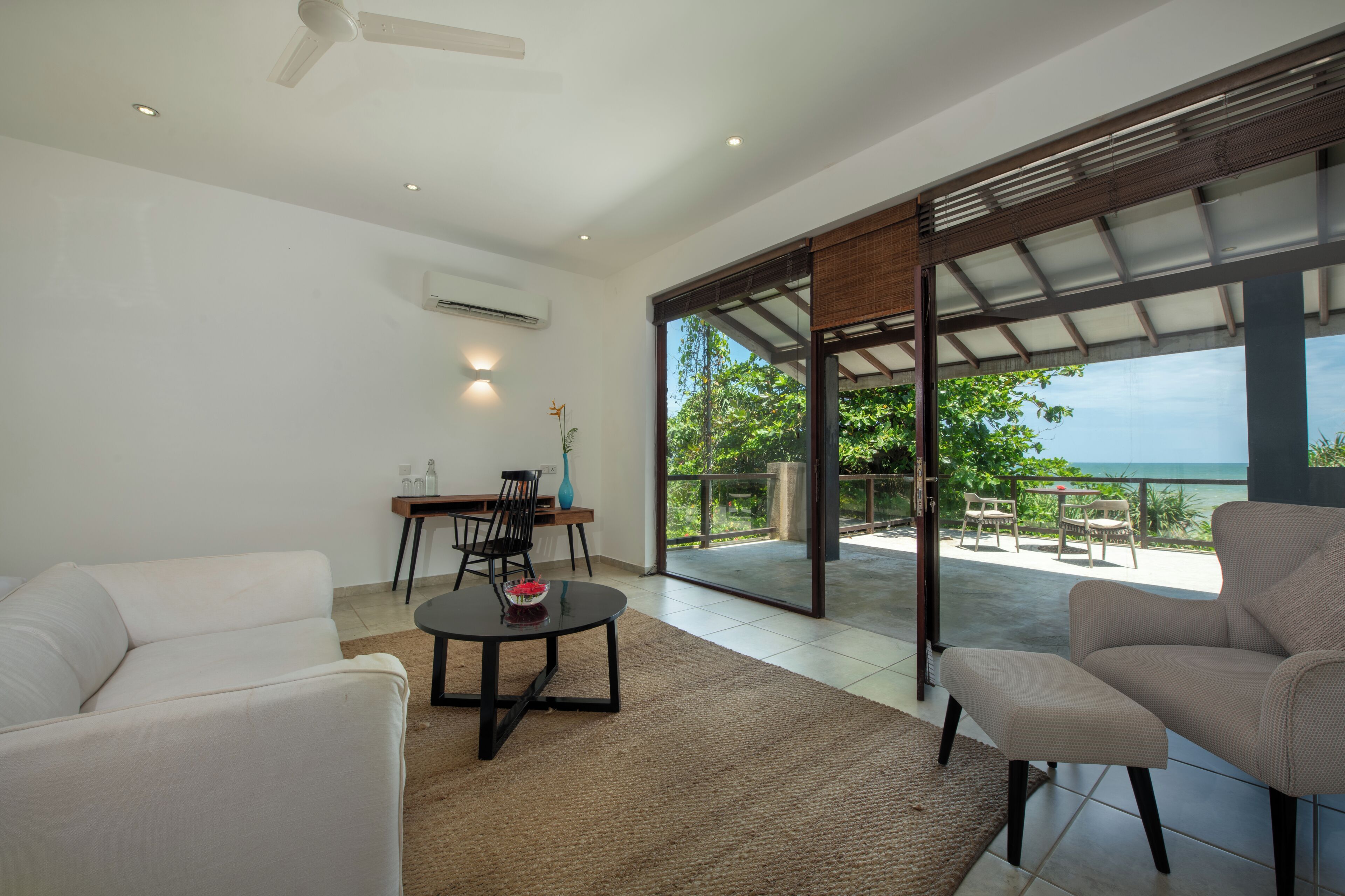 Una sala de estar moderna con un sofá, una mesa de comedor y vistas al exterior.
