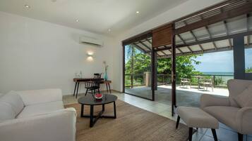 Una sala de estar moderna con un sofá, una mesa de comedor y vistas al exterior.