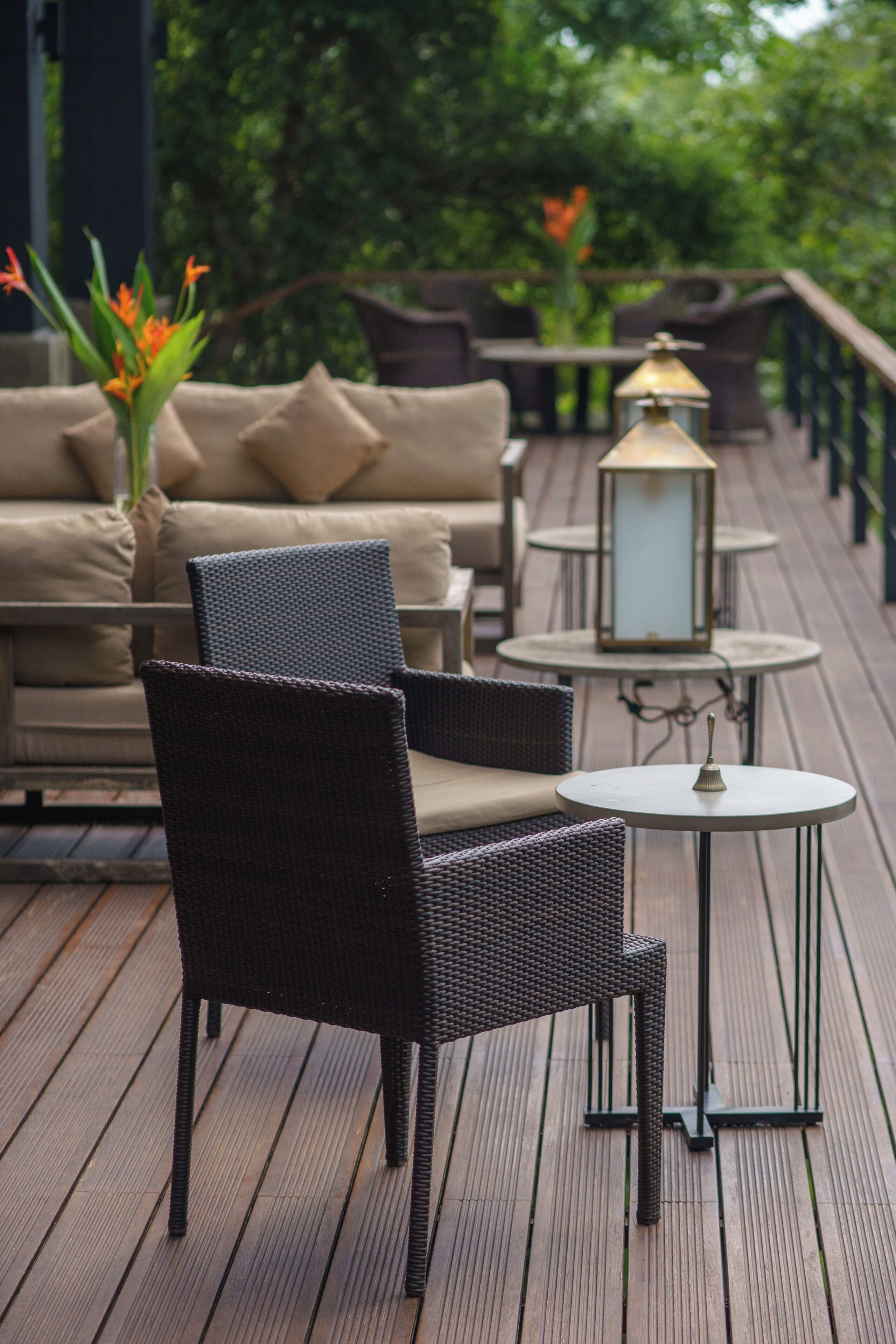A deck with wicker furniture, a sofa, and a lantern.