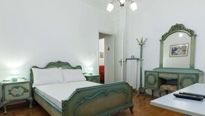 Een slaapkamer met een bed, nachtkastjes, een dressoir en een spiegel.