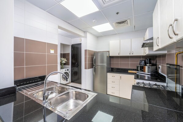 A modern kitchen with stainless steel appliances, a built-in oven, and a microwave.