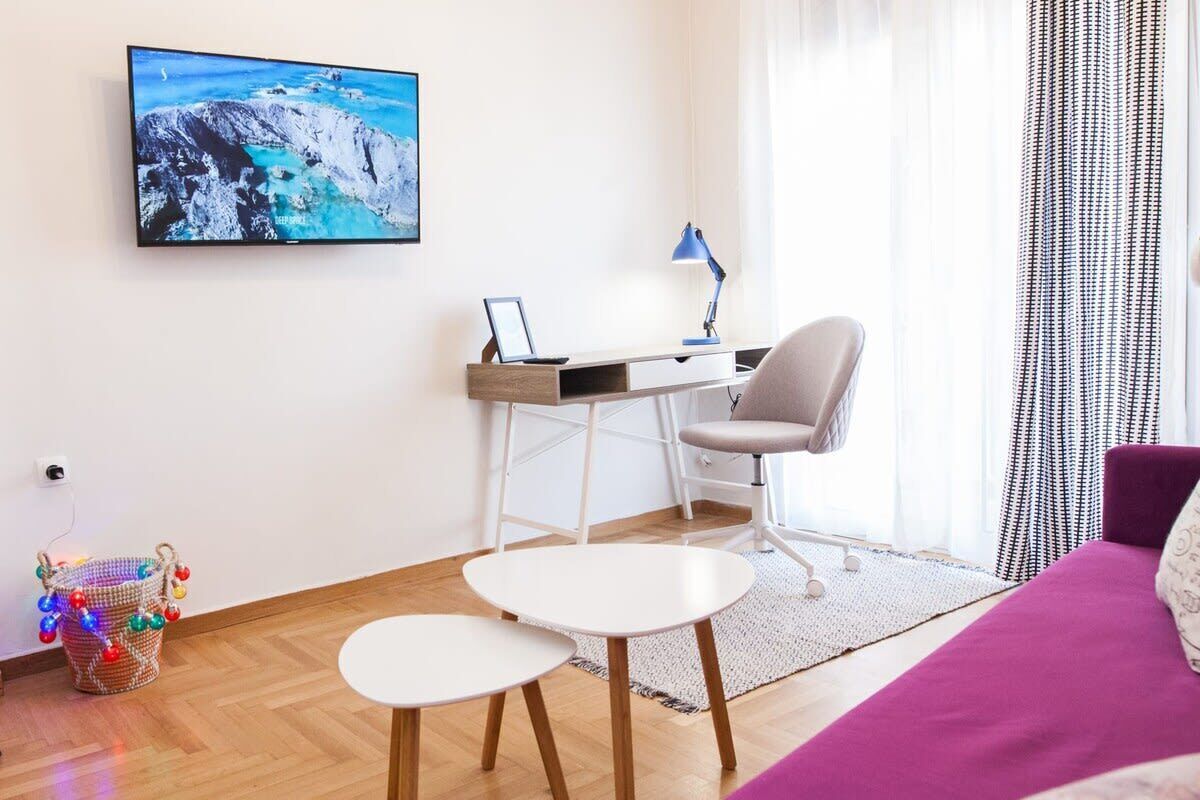 Habitació moderna amb escriptori, cadira i llit.
