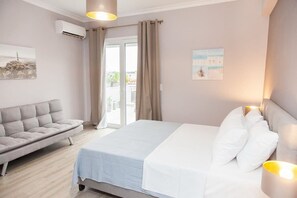 A bedroom with a bed, a sofa, and a window with curtains. - Modern Luxury Central Acropolis View Penthouse (Athens)