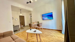 Ein modernes Wohnzimmer mit einer Couch, einem Couchtisch und einem Essbereich mit Stühlen und einem Tisch.
