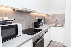 A modern kitchen with a microwave, coffee maker, and oven.