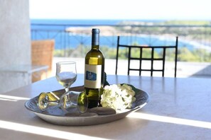 Une table avec une bouteille de vin, un verre et une assiette décorée de fleurs.