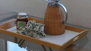 A kitchen counter with a jar of honey, a wicker container, and a metal pitcher. - Top floor 3bed 2bath with stunning 360 view (Athens)