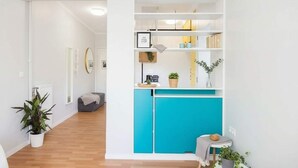 A modern interior with a kitchen area, a seating area, and a hallway.