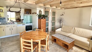 Eine moderne Küche mit Holzschränken, einem Esstisch und einer Couch.