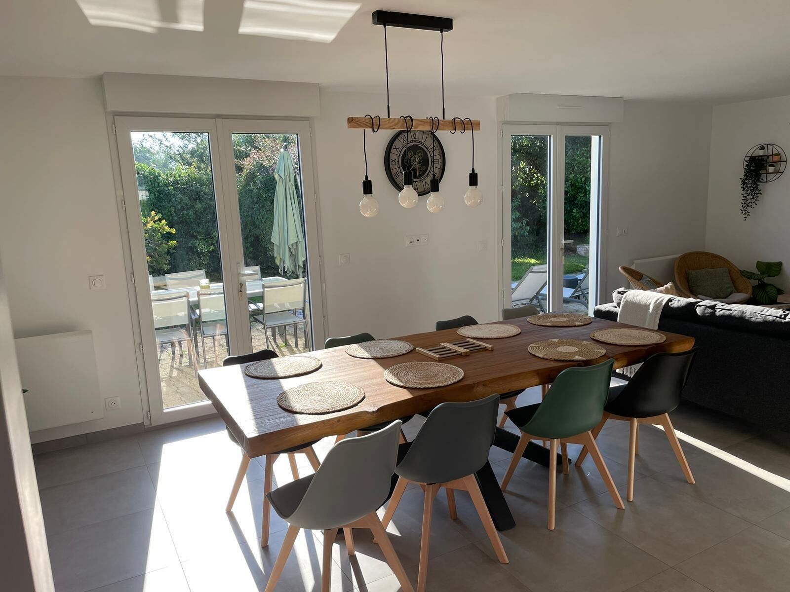 A modern dining area with a wooden table, woven placemats, and contemporary chairs.
