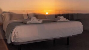Un dormitorio con cama, almohadas y toallas.