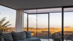 Una habitación moderna con un amplio ventanal que ofrece vistas a un paisaje desértico.