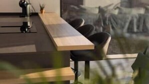Una sala de reuniones moderna con una mesa grande, sillas y un proyector.