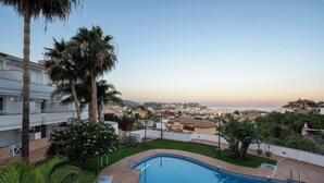 A swimming pool with a view of a residential area and a distant coastline. - APARTAMENTOS TROPICALIA ALMUÑECAR (Almunecar)