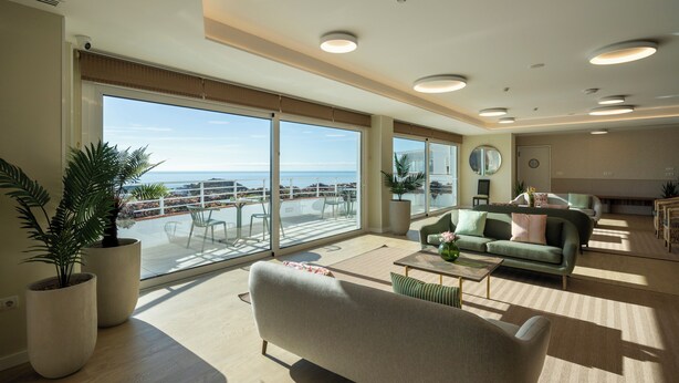 A spacious living area with a large balcony, a sofa, a coffee table, and a view of the sea. - APARTAMENTOS TROPICALIA ALMUÑECAR (Almunecar)