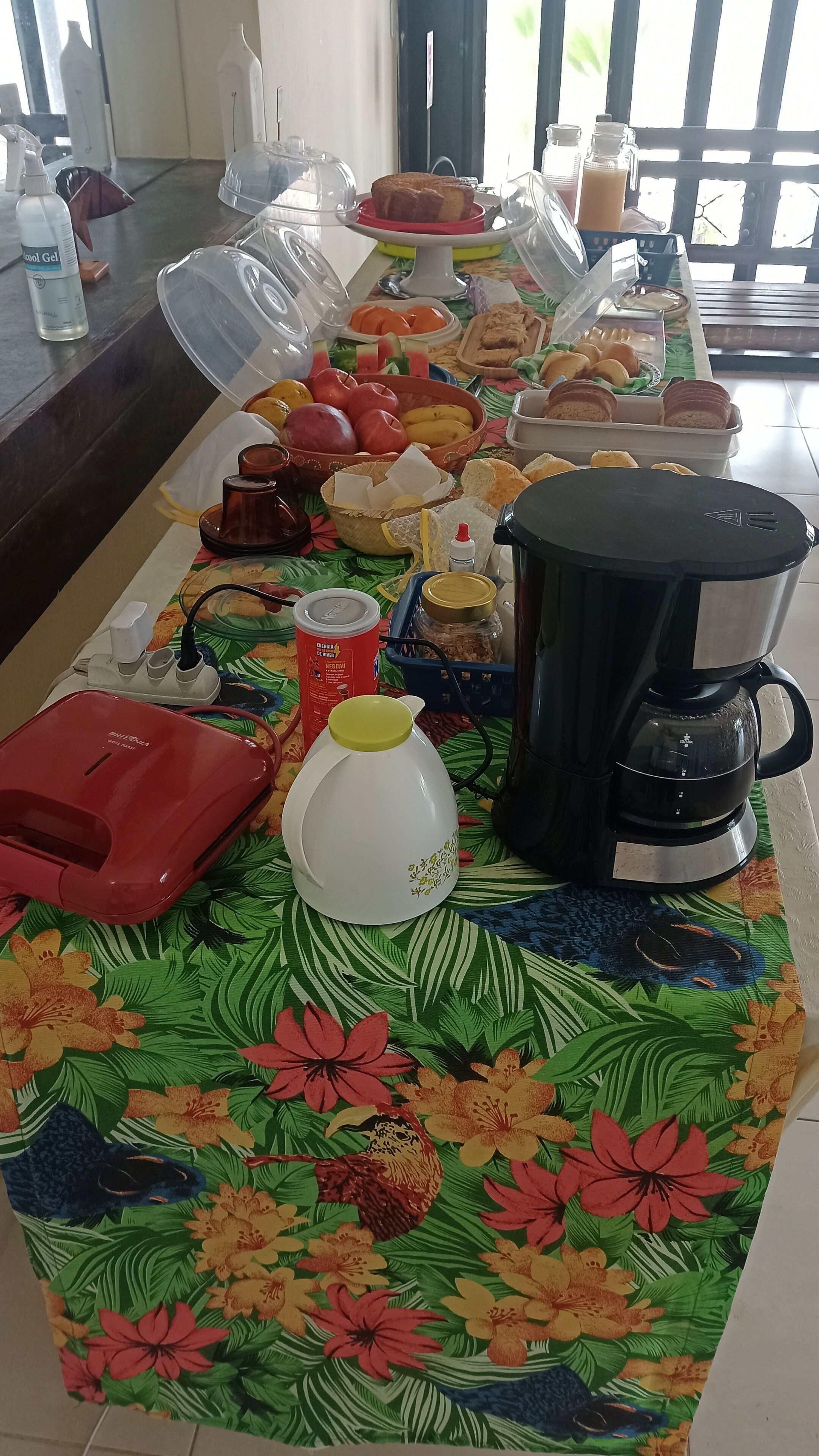 Uma mesa de buffet com diversos alimentos e uma cafeteira.