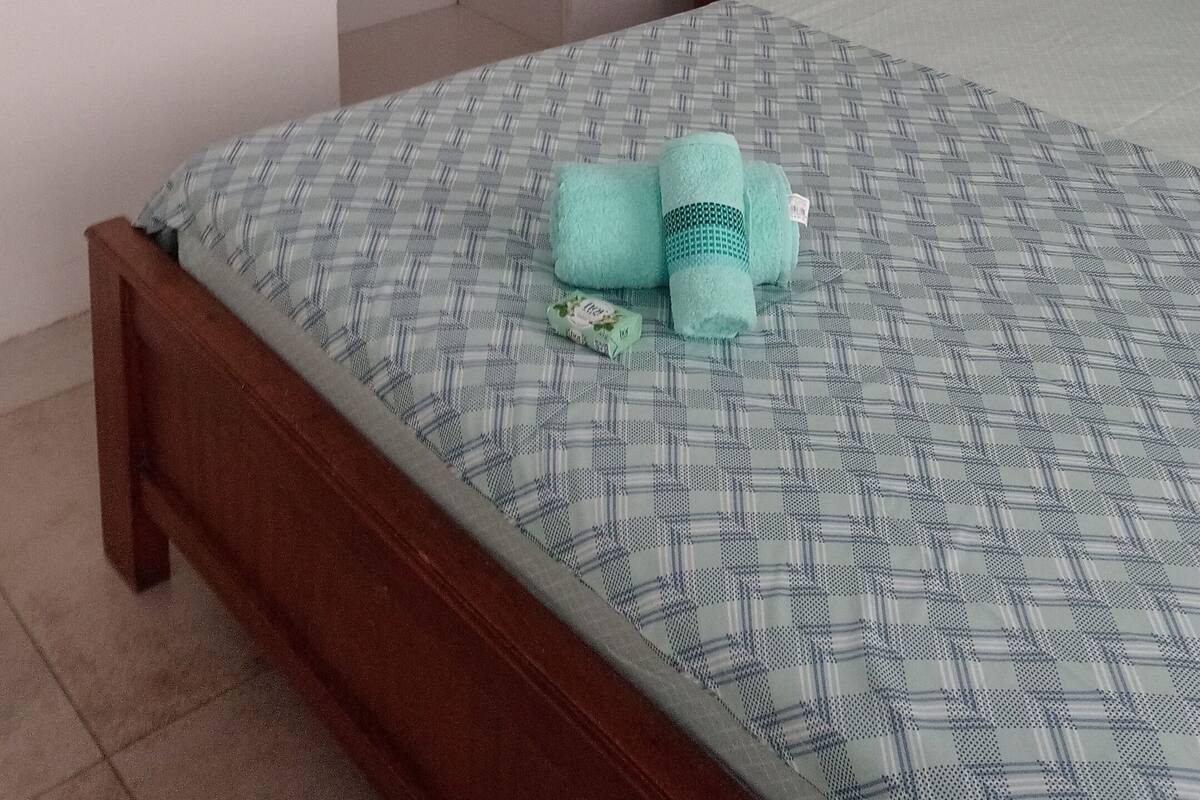 A bedroom with a bed, a nightstand, a wardrobe, and a bedside table.