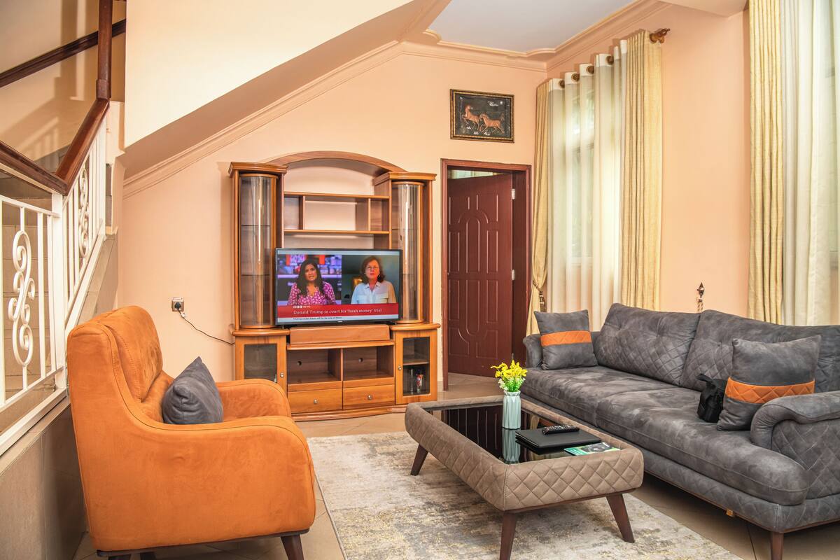 A living room with a television, a sofa, an ottoman, and a coffee table.