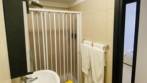 A bathroom with a white sink, a shower enclosure, and a towel rack. - Comfortable and Comfortable as at Home (Acerra)