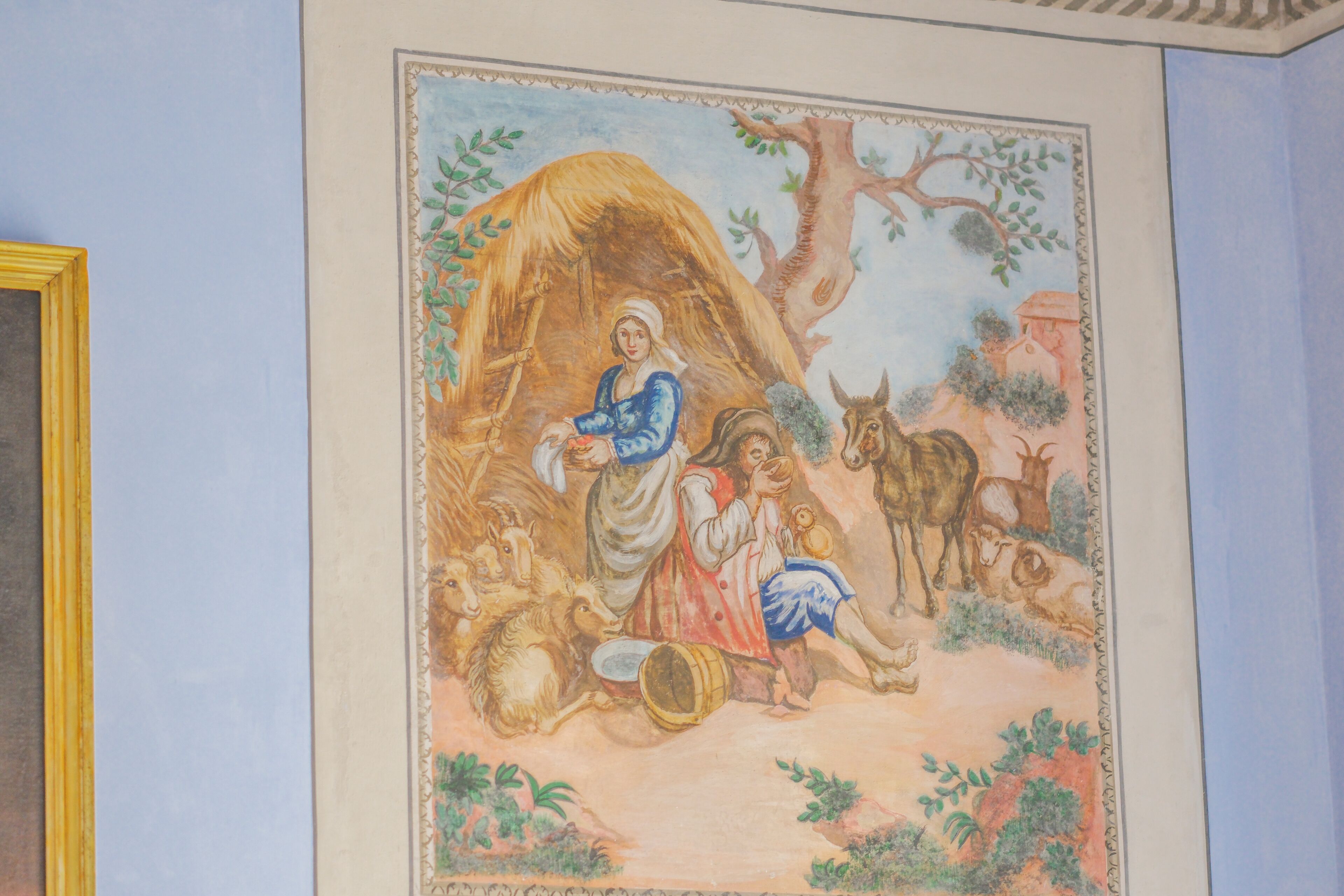 A mural with a woman and children in a rustic setting, surrounded by animals and trees.