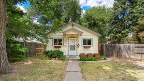 A small, single-story house with a front door, a small porch, and a wooden fence. - Old Town Retreat w/ Vintage Flair Near Csu, Bikes! (Fort Collins)