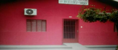 A red building with a sign that reads "POUSADA ST. RITA DE CASSIA 99 35313837-800028".