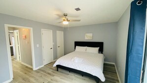 A bedroom with a bed, a ceiling fan, and a door leading to another room. - Sunny Getaway * 1BR condo close to the beach (C) (Myrtle Beach)