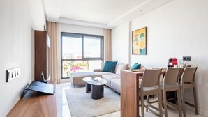 A modern living room with a sofa, coffee table, and dining area. - Charming Apartment 42 (Casablanca)