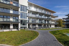 Un immeuble moderne à plusieurs étages, doté de balcons et de grandes fenêtres.