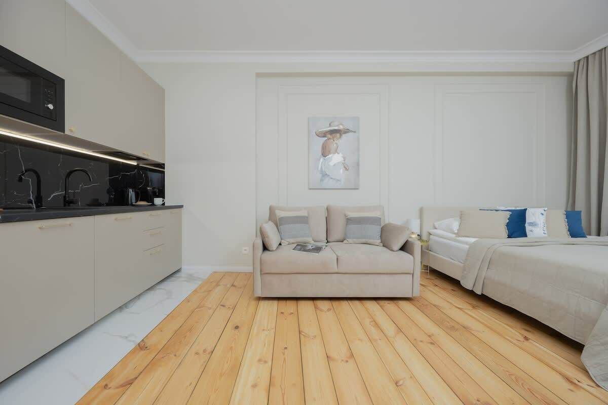 Une chambre moderne avec un lit, un canapé et un coin cuisine.