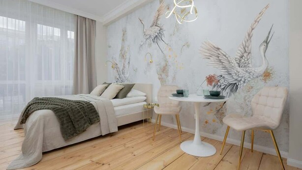 A modern bedroom with a bed, bedside table, and chairs.