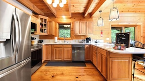 Een moderne keuken met houten kasten, roestvrijstalen apparatuur en een groot eiland.