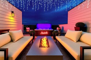 Un patio al aire libre con un jacuzzi, una chimenea y zonas de estar.